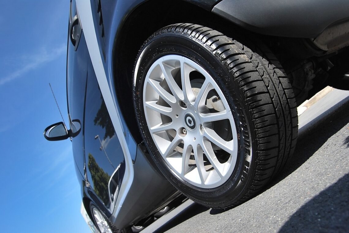 Car tire inflator next to tires, symbolizing finance savings through maintenance.